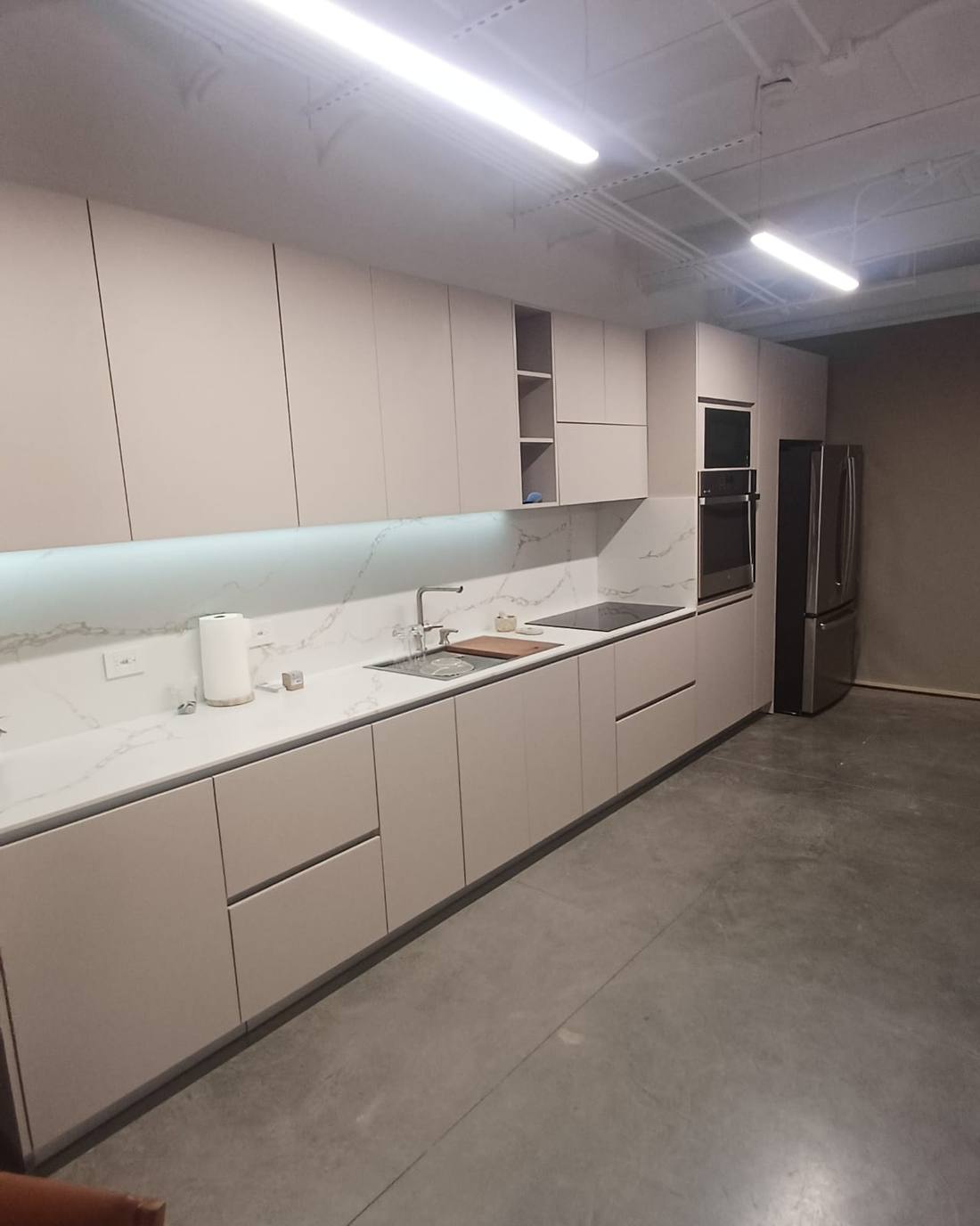 Cocina lineal a la medida en melamina con iluminación LED bajo gabinete